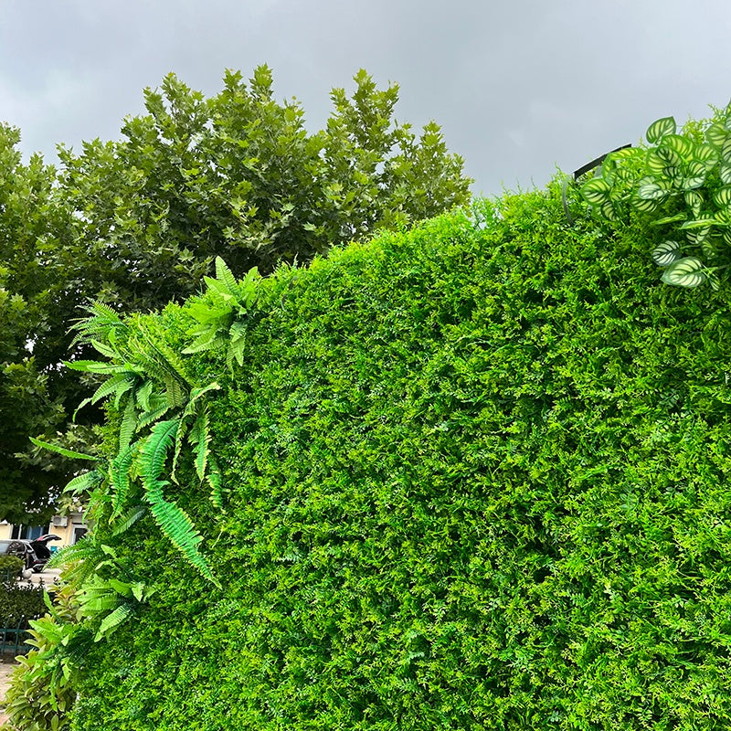 Large greenery wall backdrop for party decoration setup.